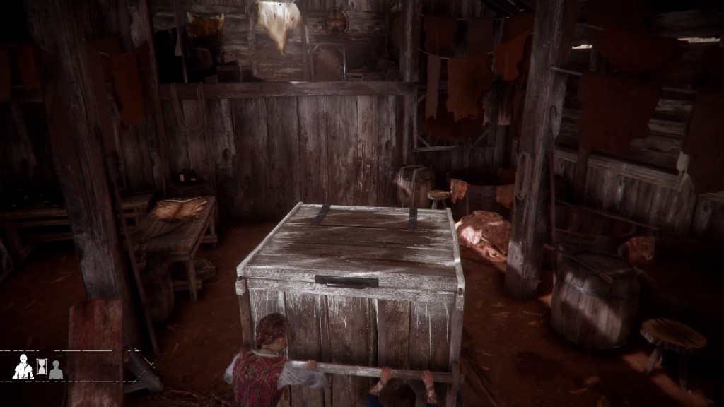 Amicia and Hugo push a large wooden box inside a barn