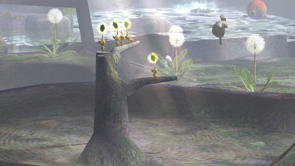 A foggy area with water in the back. In the midground there are large dandelions ready to send out their seeds. In the foreground there's a tree stump and a smaller dead tree sticking out. 5 yellow Pikmin stand/rest on its branches.